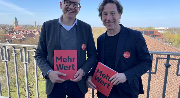 LWL-Chefdenkmalpfleger Dr. Holger Mertens und Stefan Rethfeld vom LWL präsentieren das Magazin "MehrWert" auf dem Turm des Landeshauses in Münster. Foto: LWL
