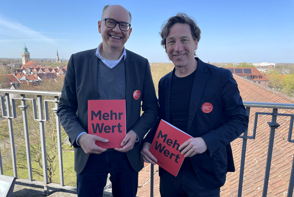 LWL-Chefdenkmalpfleger Dr. Holger Mertens und Stefan Rethfeld vom LWL präsentieren das Magazin "MehrWert" auf dem Turm des Landeshauses in Münster. Foto: LWL